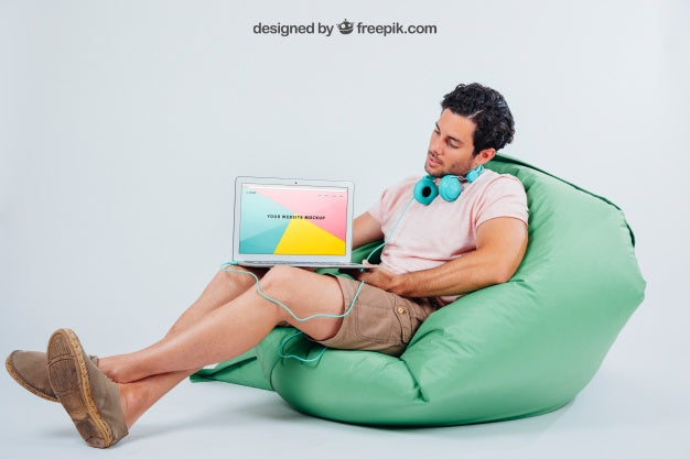 Young Guy Sitting With Earphones And Laptop'S Mock Up Psd