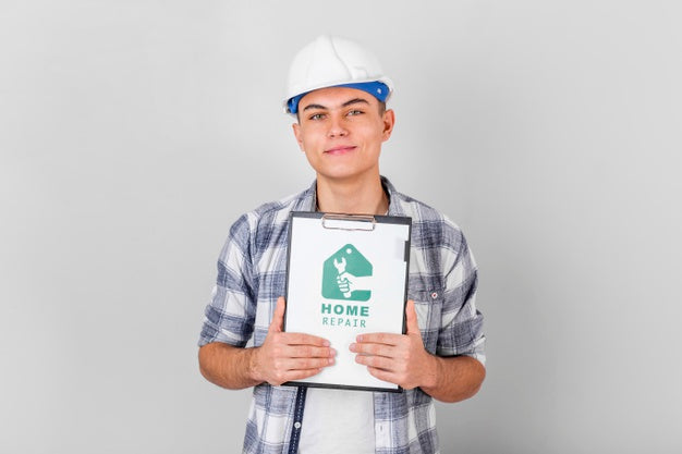Young Handyman Holding A Mock-Up Clipboard Psd