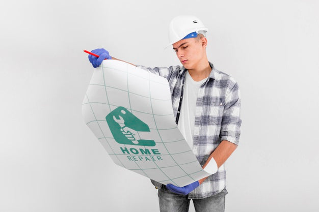 Young Handyman Looking On A Blueprint Psd
