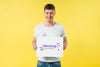 Young Man Standing And Holding A Mock-Up Front View Psd