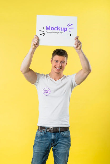 Young Man Standing And Holding A Mock-Up Psd