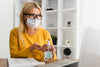 Young Woman At Desk With Mask And Disinfectant Mock-Up Psd