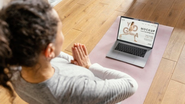 Young Woman At Home Doing Yoga With Laptop Psd