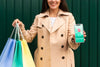 Young Woman Holding Shopping Bags And A Phone Mock-Up Psd